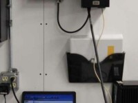 A workspace featuring a computer, cable management, and wall-mounted storage for documents and equipment.